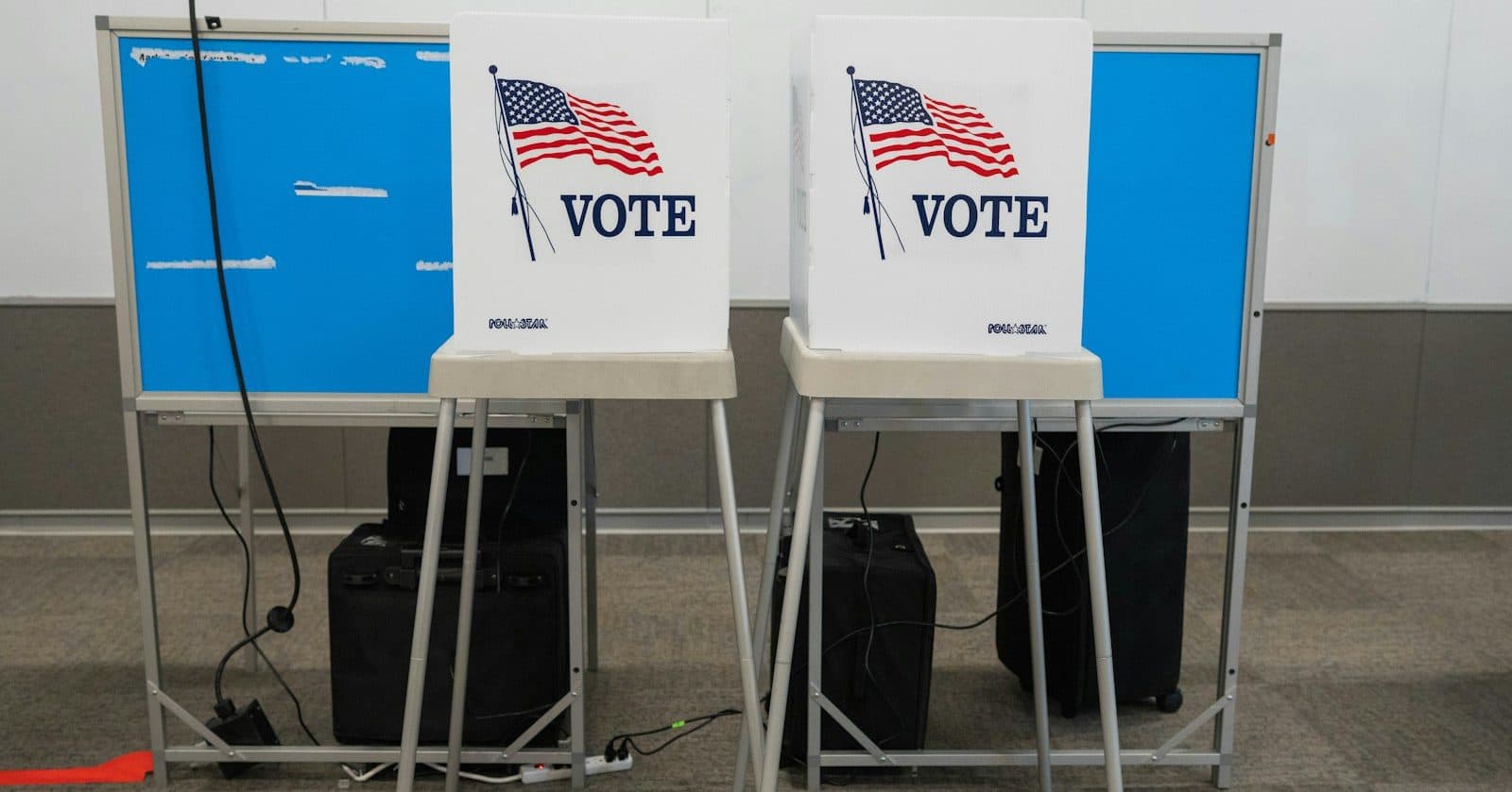 Two empty voting booths with VOTE signs at a public polling place